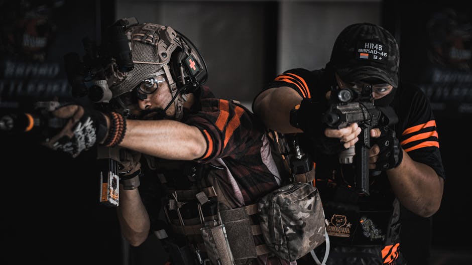 Two armed men in tactical gear engaging in realistic indoor combat training.