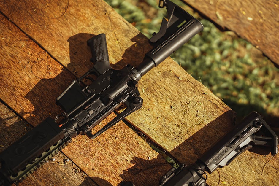 AR-style rifle displayed on wooden planks in natural light, showcasing tactical features.